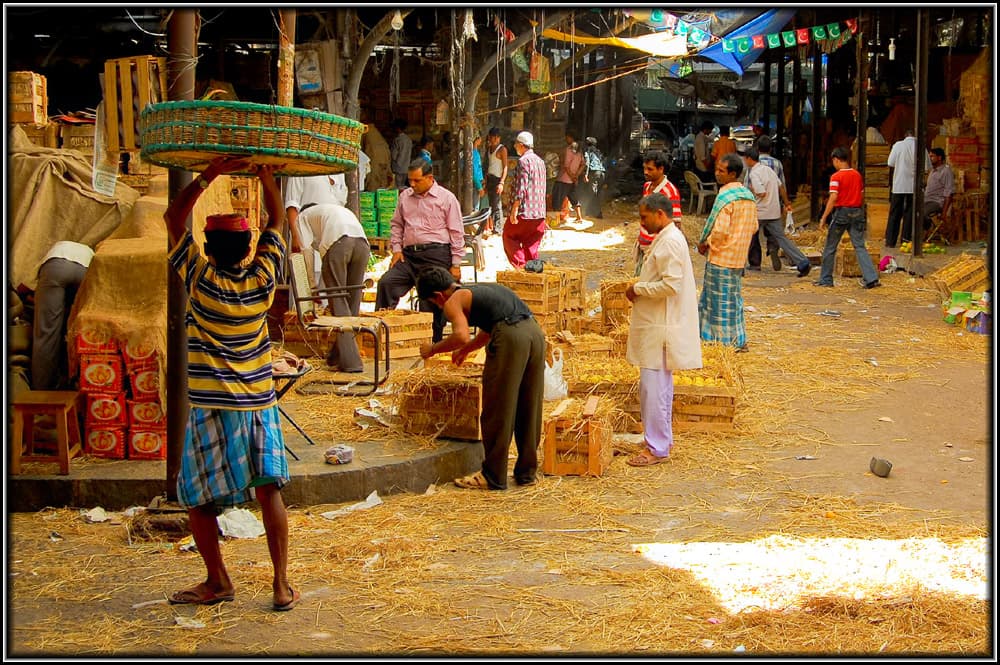 Interior of a wholesale market hall with baskets, straw and porters at work